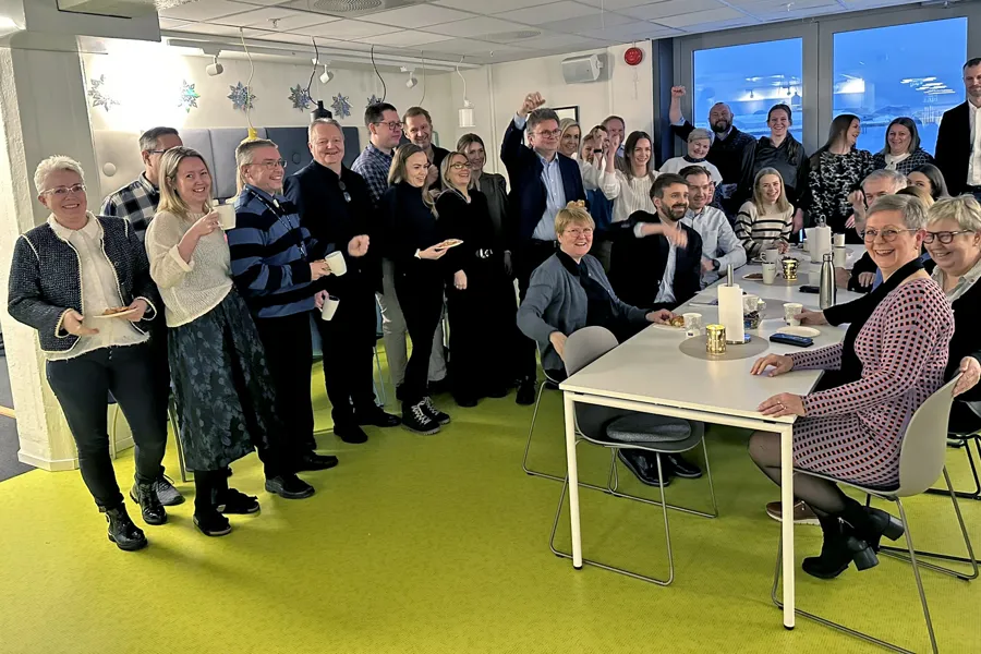 En gruppe mennesker som står rundt et bord