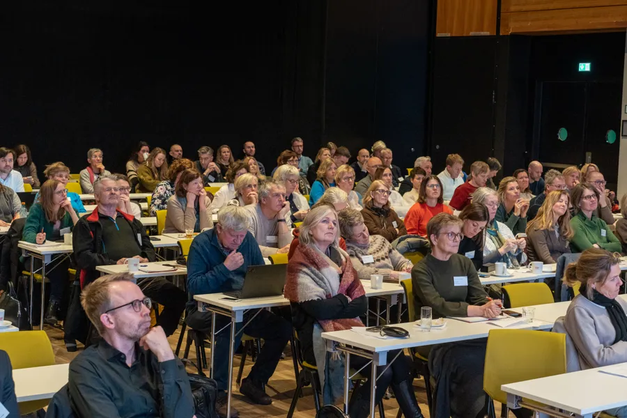 En gruppe mennesker som sitter ved bordene