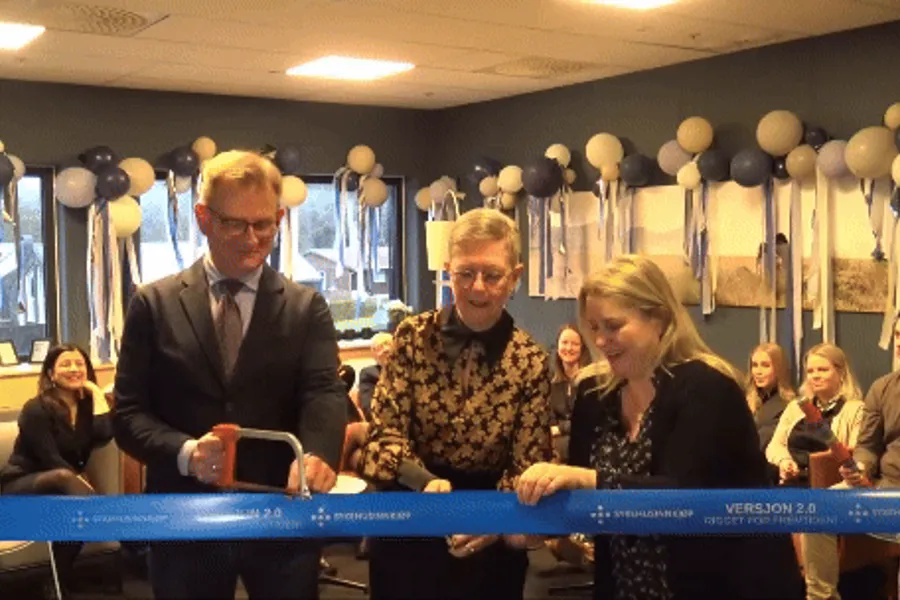 Konfetti sprenges i luften idet et bånd klippes over med saks av en kvinne.