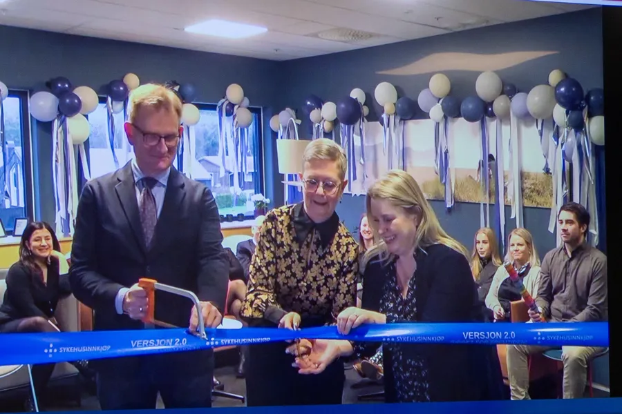 En gruppe mennesker står bak et banner som skal klippes. Ballonger i bakgrunnen.