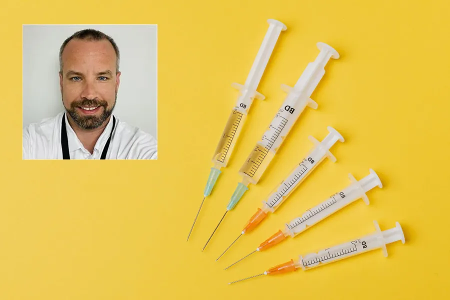 En mann som smiler med en gruppe blyanter foran seg