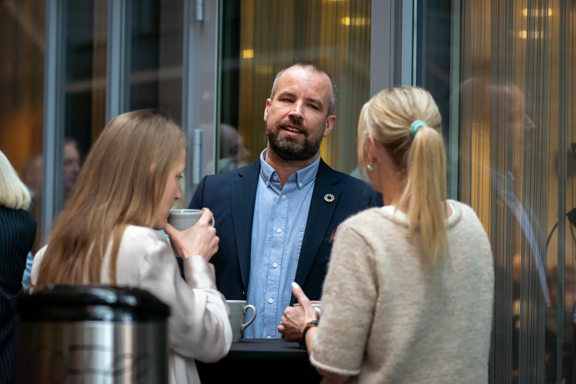 En mann som holder en kopp og snakker med en kvinne