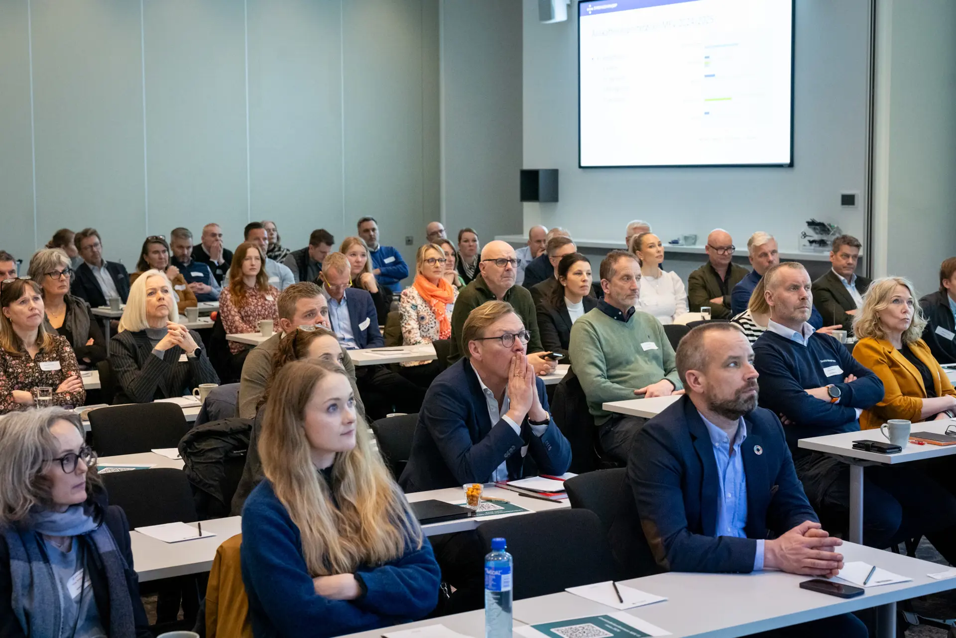 En gruppe mennesker som sitter i et rom