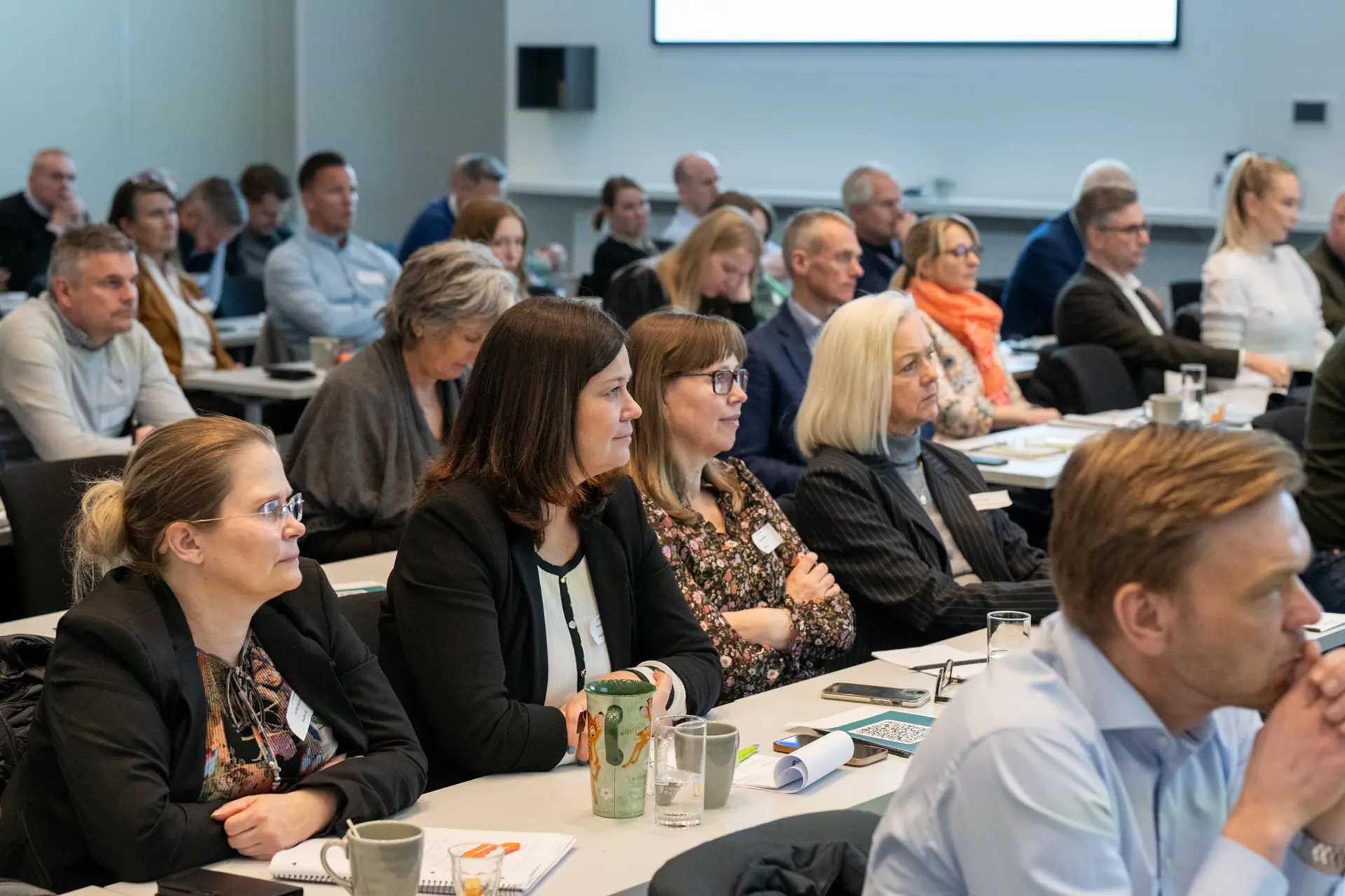 En gruppe mennesker som sitter ved bordene