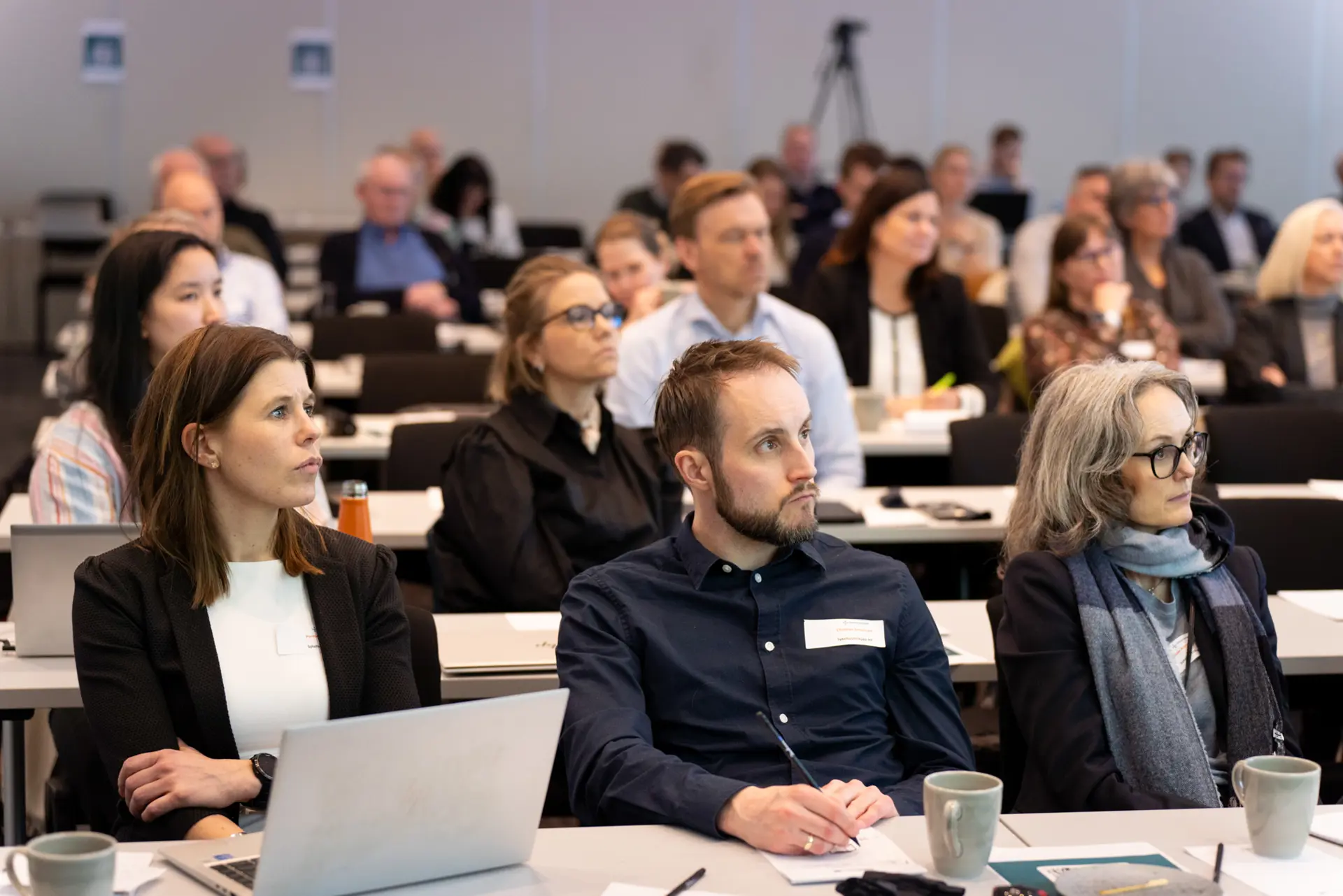 En gruppe mennesker som sitter ved bordene