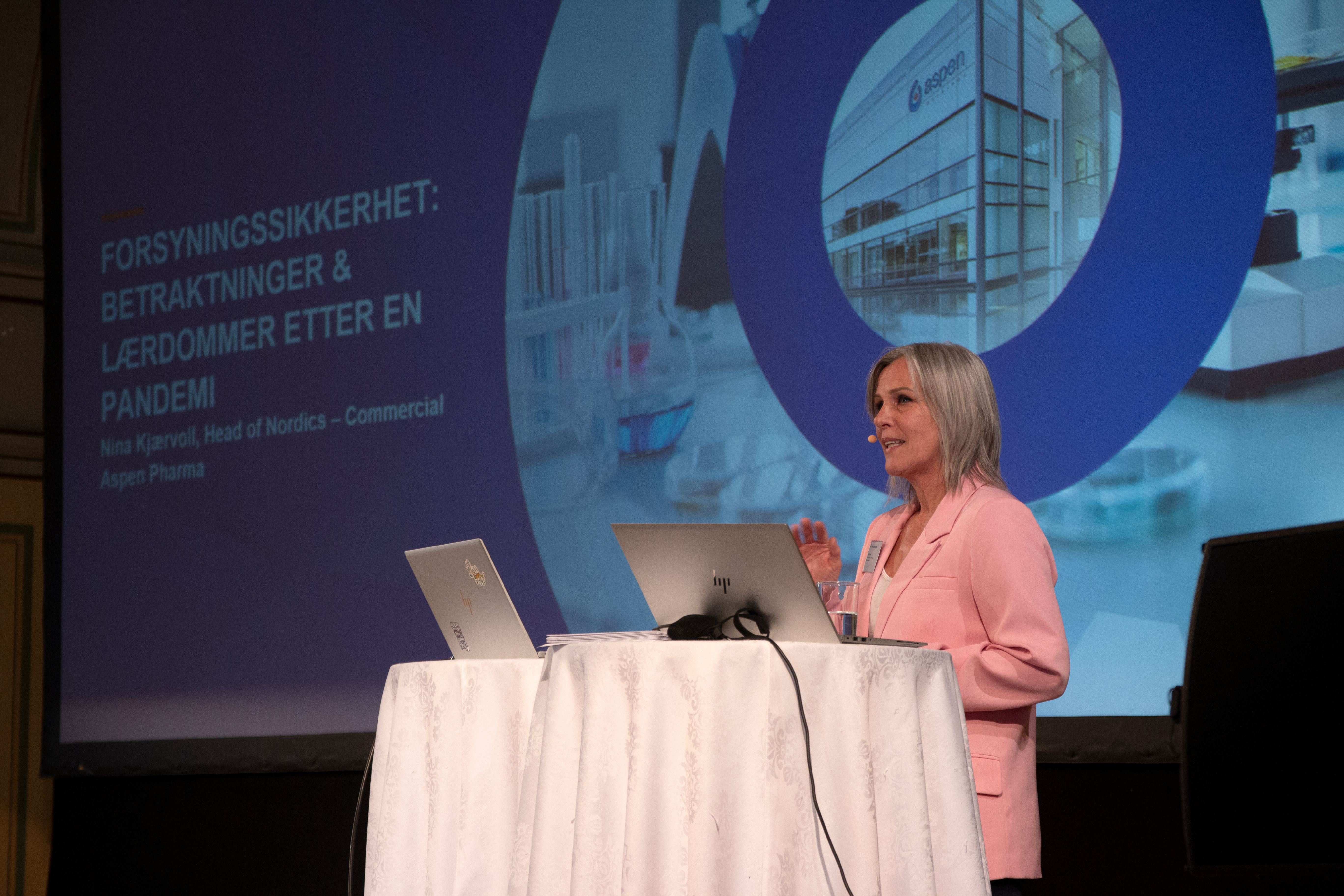 En dame står på en scene og snakker.