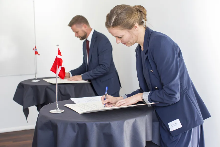 Helseminister Bent Høie og Danmarks helsesminister Ellen Trane Nørby signerer en avtale.