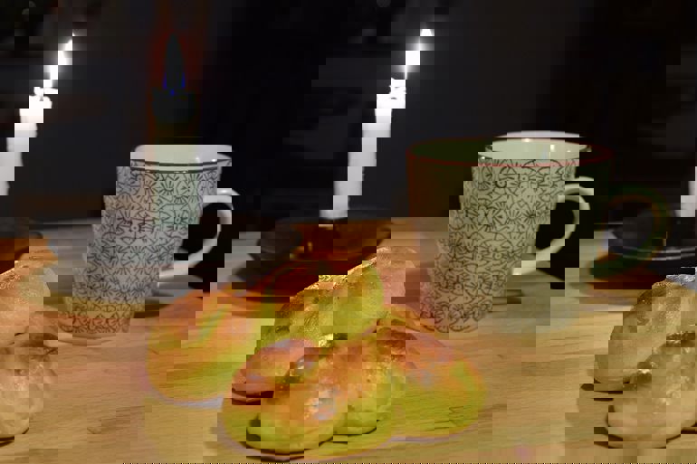 Stearinlys, kaffekopp og lussekatt.
