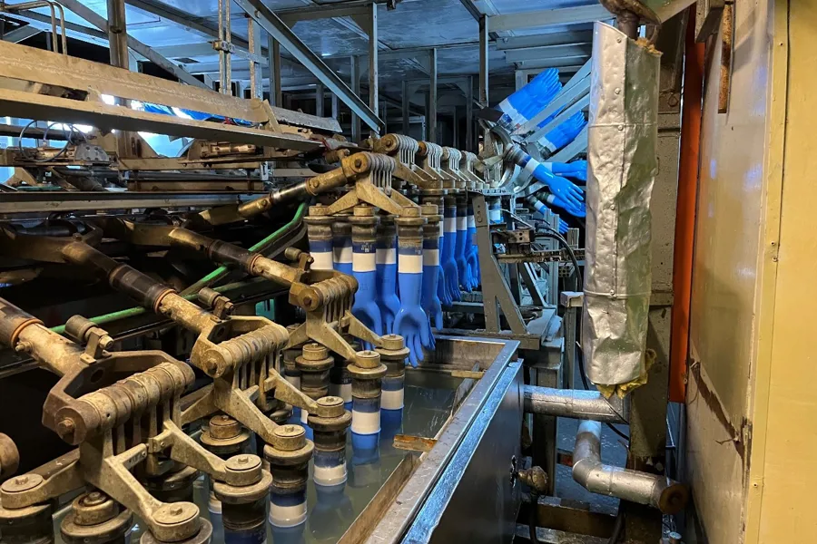 En produksjonslinje som produserer hansker på en fabrikk.