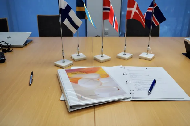 Et skrivebord med flagg og papirer på