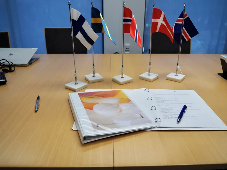 Et skrivebord med flagg og papirer på