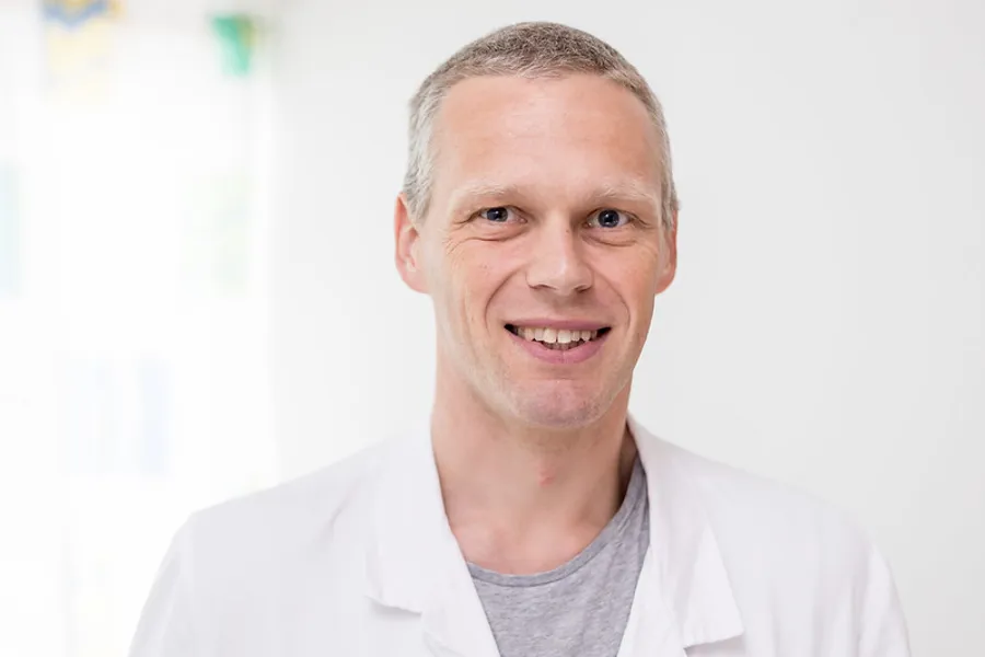 En mann som smiler til kameraet