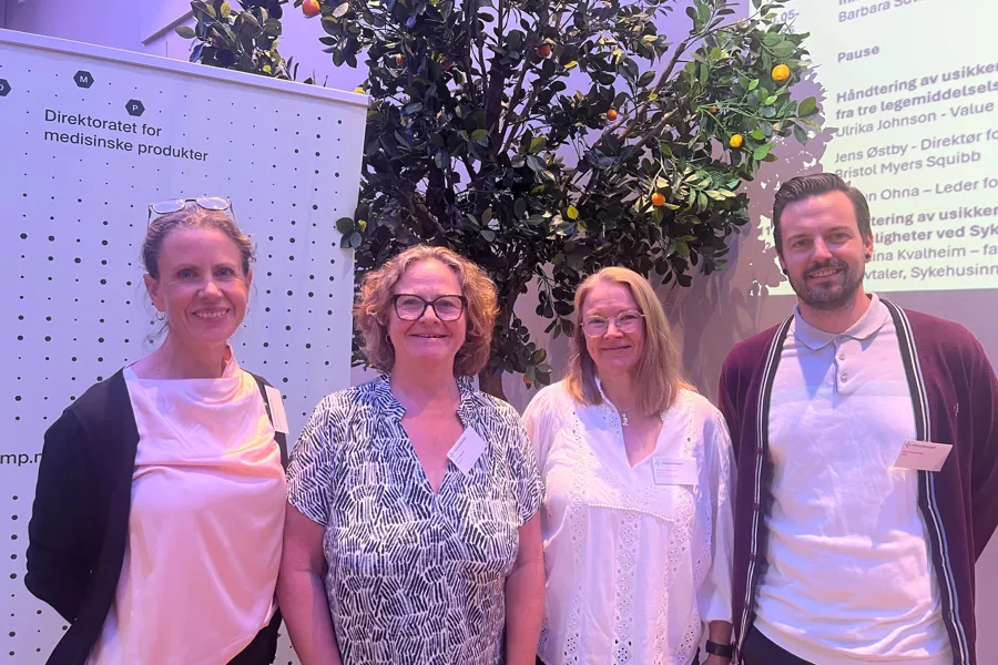 En gruppe mennesker som poserer for et bilde foran et juletre