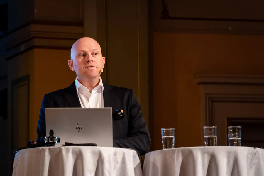 En mann som sitter ved et bord med en bærbar datamaskin