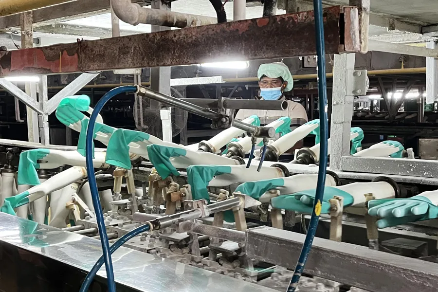 En person i en maske på en fabrikk