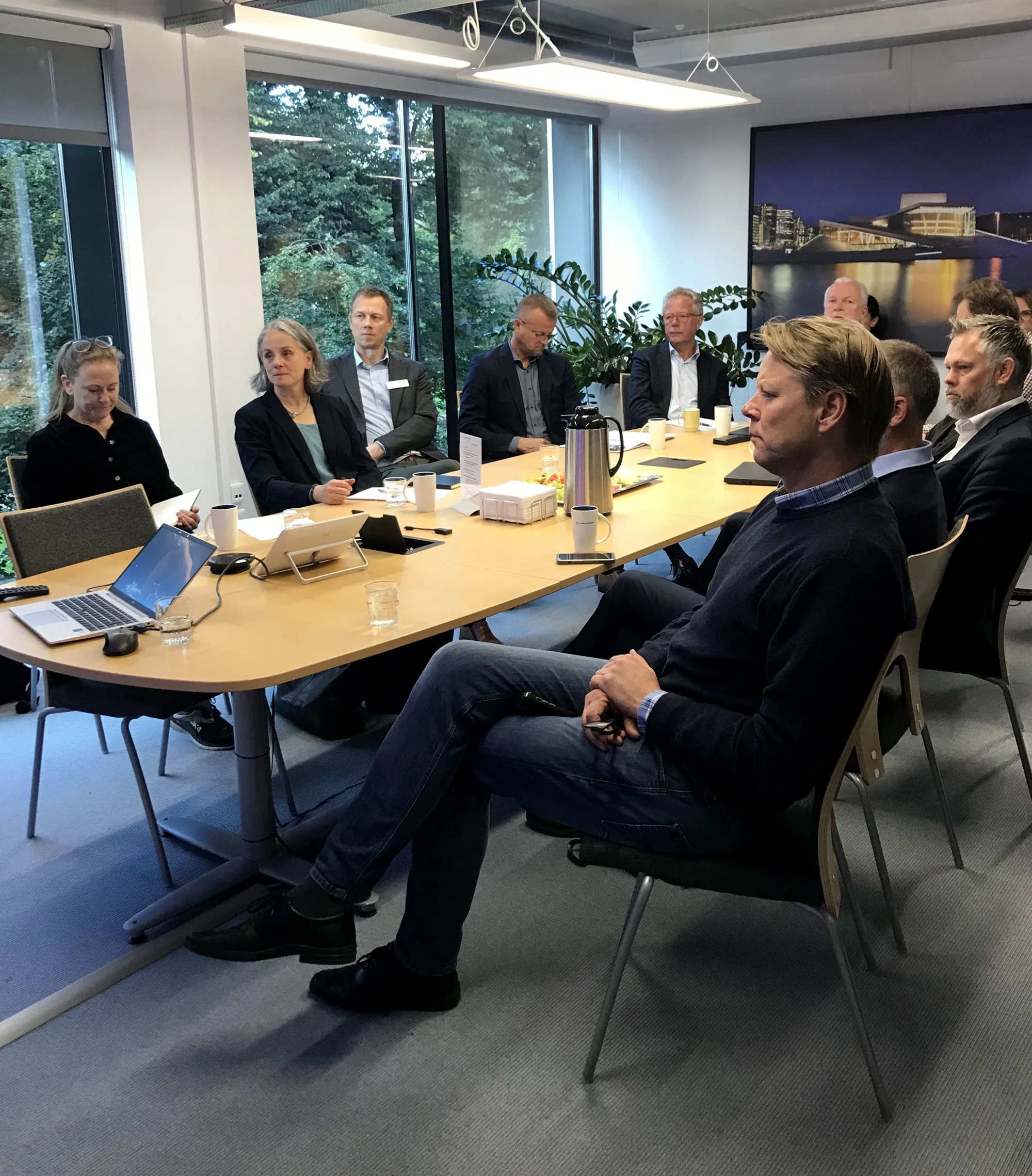 En gruppe mennesker som sitter rundt et bord med bærbare datamaskiner