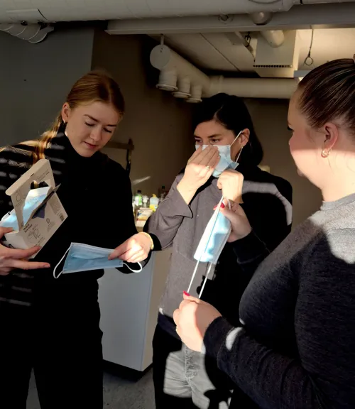 En gruppe kvinner i et rom tester munnbind.