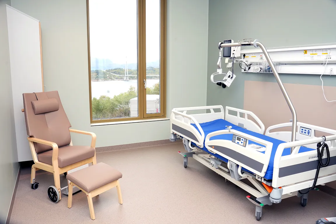 Et sykehusrom med seng og stol