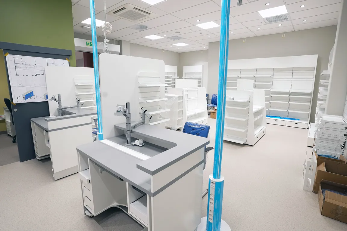 Et rom med hvite hyller og blå stolper